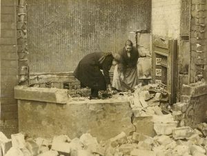 Photograph of mother and daughter sifting through rubble after a fire, illustrating a post about life after the destruction of Jerusalem as depicted in the Biblical Book of Lamentations.