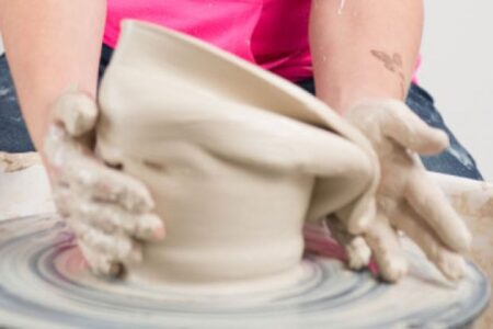 Hands working a potters wheel as the clay droops to one side illustrating a post about Jeremiah and his prophetic theatre